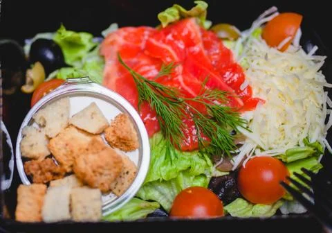 Caesar salad with red fish, crackers, tomatoes and cheese Foto stock