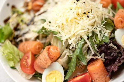 Caesar salad with red fish, herbs and grated cheese. Close-up shot. Horizontal Stock Photos