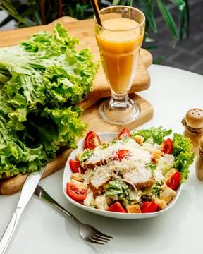 Caesar salad with side herbs and juice Stock Photos