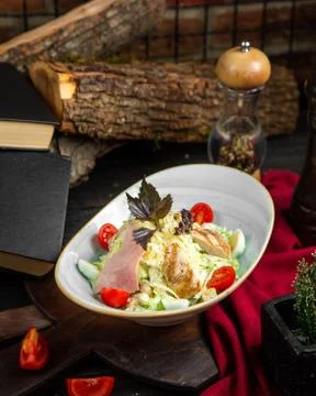 Caesar salad with a slice of chicken ham and quail eggs Stock Photos