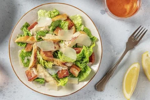 Caesar salad, top flat lay shot with wine and lemons Stock Photos