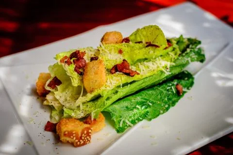 Caesar's salad with bacon bits and crispy croutons on white porcelain plate Foto stock
