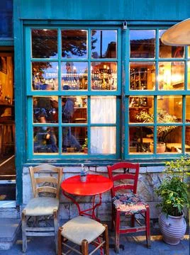 Cafe bar windows door table chairs in the evening in ioannina city greece Stock Photos