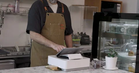 Cafe barista operating digital POS terminal at marble counter while standing Stock Footage 308059533