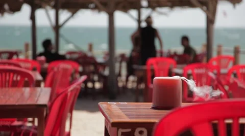 Cafe on the beach: red plastic chairs and wooden tables. Stock Footage 44827795