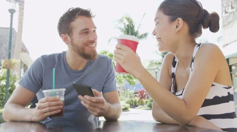 Cafe couple looking at smart phone screen app laughing having fun on date Stock Footage 47342187