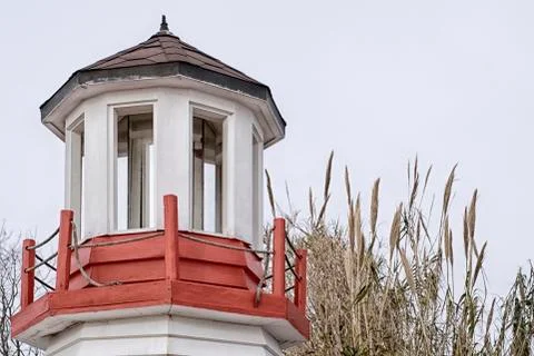 Cafe decor in the form of a red-white wooden lighthouse on the background of  Stock Photos