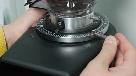 Cafe employee selects level on bean grinding machine twisting Stock-Footage 306622275