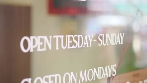 Cafe hours sign shows open days of Tuesday to Sunday Stock Footage 346114094