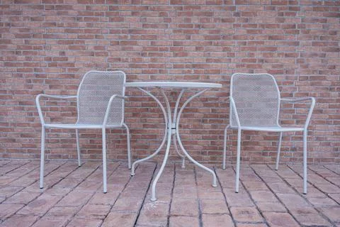 Cafe interior table chairs against brick wall background. Stock Photos