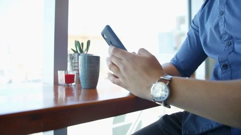 Cafe man puts down phone and picks up coffee Video stock 108514789