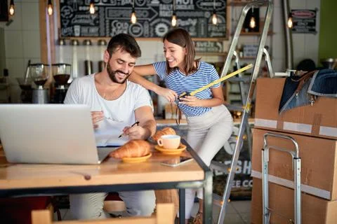 Cafe managers working on laptop ready to open their cafe.. Stock Photos