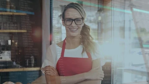 Cafe owner in apron smiling behind counter rising sun causing code overlays over Stock Footage 334185327