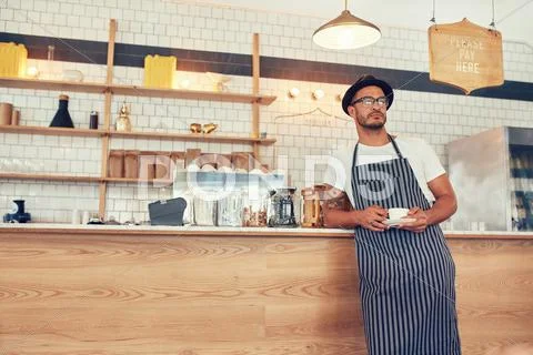 Cafe owner standing at counter with a cup of coffee Stock Photos