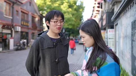 A cafe on a public road where many people walk in Shanghai, China. A young Видео 300840800