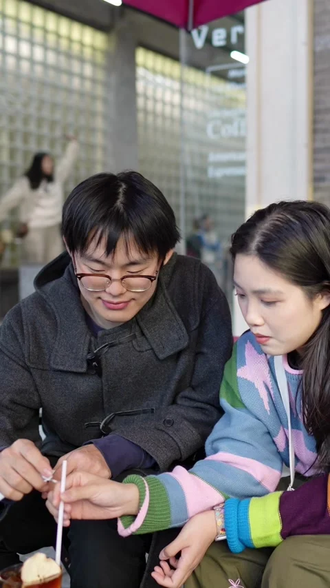 A cafe on a public road where many people walk in Shanghai, China. A young Vidéo 301715991