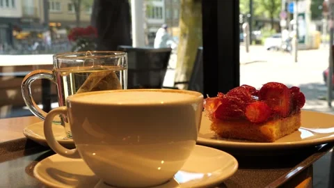 Cafe scene glass mug with a steeping tea bag and a white ceramic cup 스톡 동영상 333474178