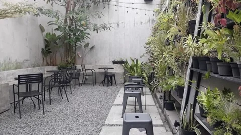 A café table and chairs with stone floors and plant decorations on the walls Video stock 220388092