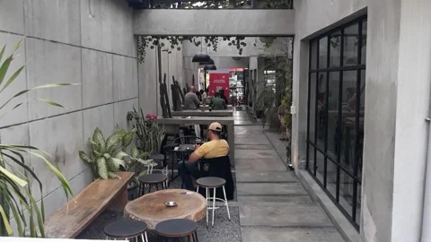 A cafe table and chairs with stone floors and plant decorations on the walls Stock Footage 220393004