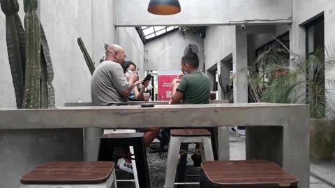 A café table and chairs with stone floors and plant decorations on the walls 스톡 동영상 220393009