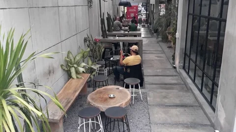 A café table and chairs with stone floors and plant decorations on the walls Stock-Footage 220393010