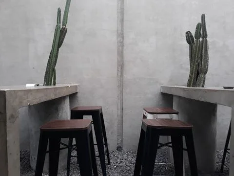 A café table and chairs with stone floors and plant decorations on the walls Stockfoto's