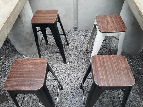 A café table and chairs with stone floors and plant decorations on the walls 스톡 사진