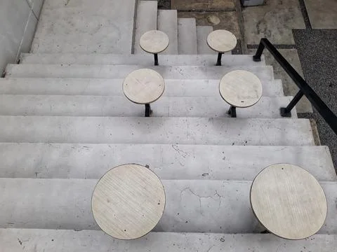 A café table and chairs with stone floors and plant decorations on the walls 스톡 사진