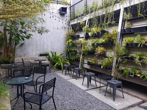 A café table and chairs with stone floors and plant decorations on the walls 写真素材