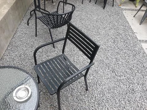A café table and chairs with stone floors and plant decorations on the walls Stockfoto's