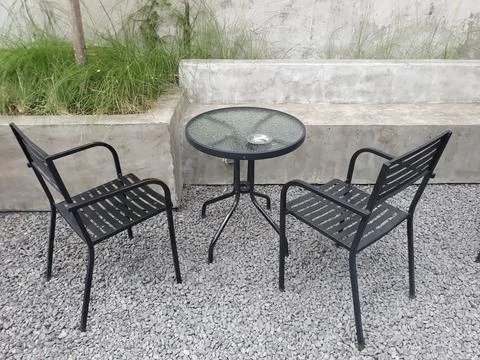 A café table and chairs with stone floors and plant decorations on the walls Stockfoto's