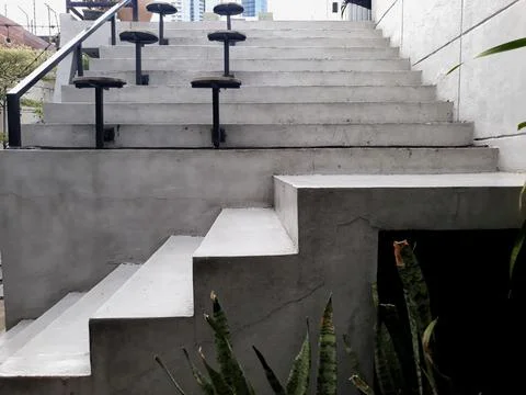 A café table and chairs with stone floors and plant decorations on the walls 스톡 사진