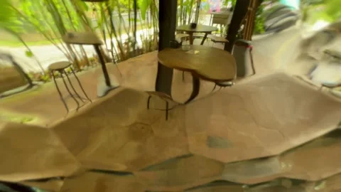 Cafe table and chairs through glass window distorting the view. Abstract Stock Footage 171006602