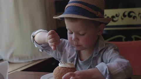 In cafe table child boy in cute hat sitting and eating dessert cake. Sweet Video stock 274606047
