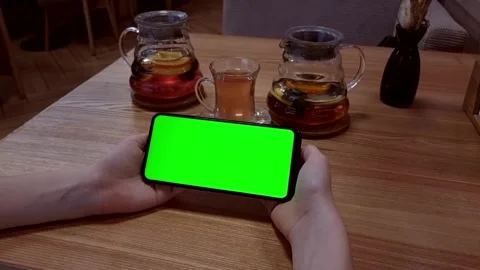 In a cafe at a table with tea, the hands of a young girl are holding Stock Footage 282255568