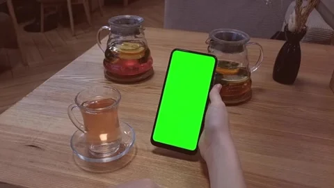 In a cafe at a table with tea, the hands of a young girl are holding vertically Stock Footage 282908999