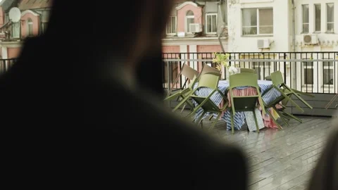 A cafe with a terrace where it is raining. Restaurant visitors wait for the rain Stock Footage 318064598