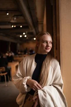 Cafe visitor drinks coffee alone. Beautiful blonde girl whiles away time Photos