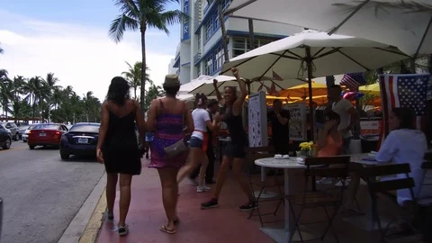 Cafe waiters dancing and entertaining at pavement cafe while tourist passing by Stock Footage 116414794