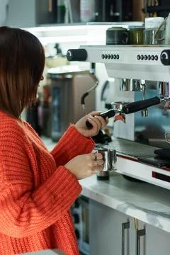 Cafe worker inserting portafilter into espresso machine Stock Photos