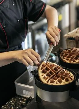 Cafe worker making belgian waffles with professional machine Stock Photos