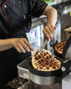 Cafe worker making belgian waffles with professional machine Stock Photos