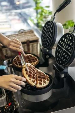 Cafe worker making belgian waffles with professional machine Stock Photos