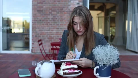 Cafe worker writes notes and organizes daily tasks during her shift 動画素材 345028726