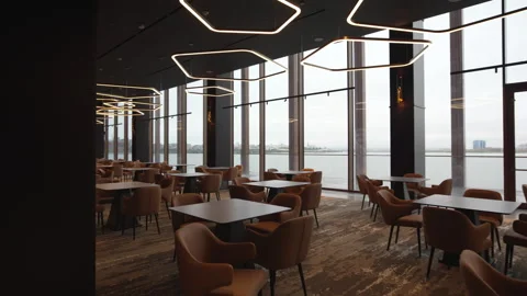 Cafeteria features tables with soft chairs in dark tones Stock Footage 316754199
