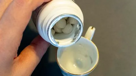 Caffeine tablets are poured into a cup like coffee Stock Photos