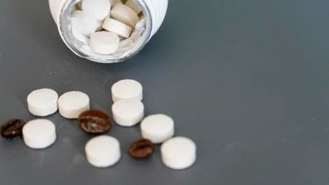 Caffeine tablets scattered from the packaging Stock Photos