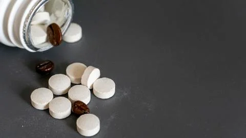 Caffeine tablets scattered from the packaging onto the table Stock Photos