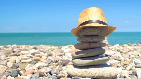 Cairn on the beach. a straw hat. Stock Footage 115193869