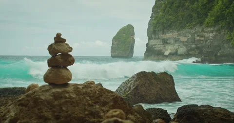 Cairn Overlooking Ocean Waves. Balanced stones foreground the powerful sea. Stock Footage 260194766